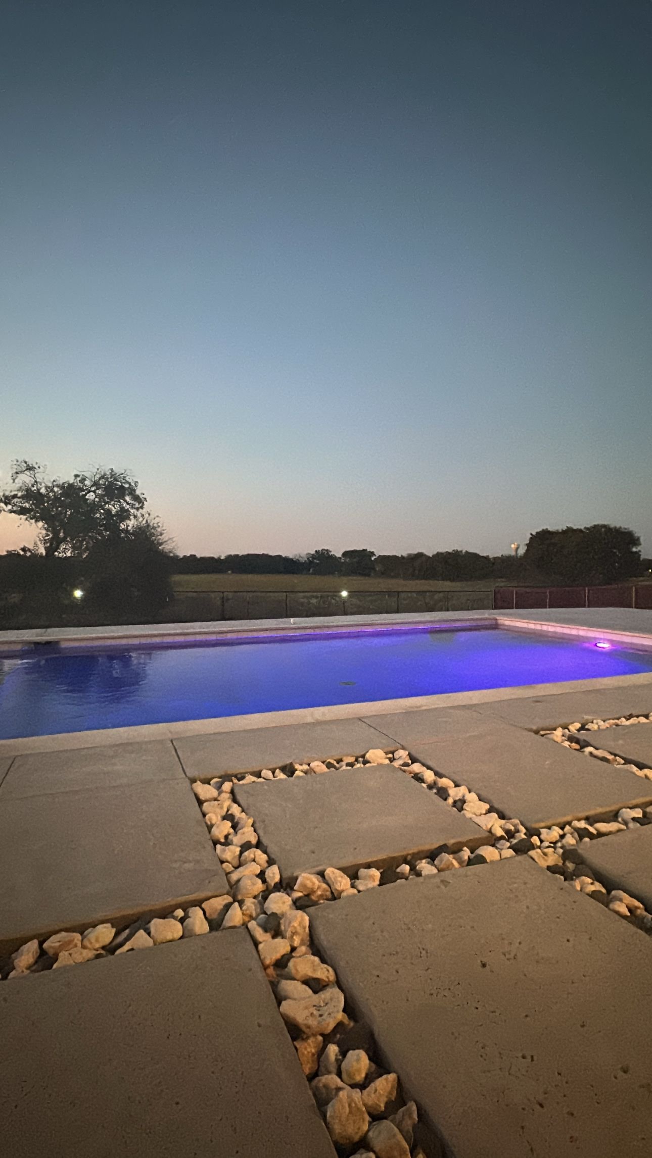 Modern geometric gunite pool with travertine coping — Johnson County, TX